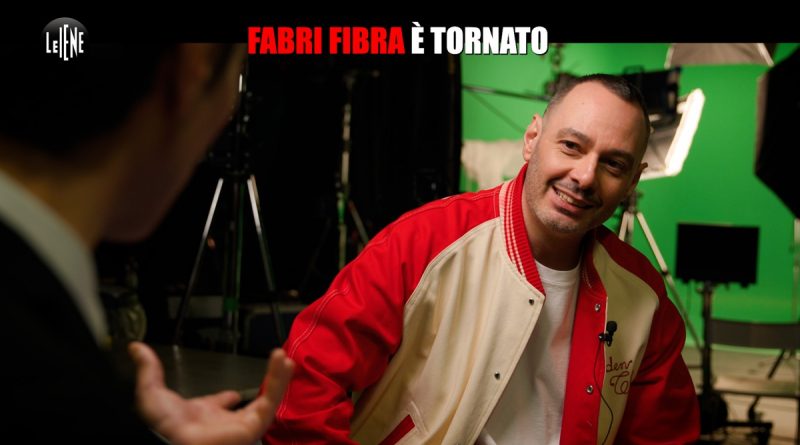 “Agitato? Stanotte alle 00:00 usciva il pezzo e mi sono guardato una serie di Bin Laden. Ahahahah”. Comincia così l’incontro tra Wad e Fabri Fibra, di fronte alle telecamere de “Le Iene”, a distanza di anni dalla sua ultima intervista tv. Nel servizio di Riccardo Spagnoli - in onda stasera, in prima serata, su Italia 1 - Wad ha analizzato insieme al rapper il suo ultimo lavoro discografico, seguendolo anche dietro le quinte del videoclip, proprio nel giorno dell’uscita del singolo. A tre anni dal suo ultimo album, il rapper torna con Che gusto c’è, il singolo che anticipa Mentre Los Angeles brucia, il nuovo disco che promette di scuotere la scena musicale italiana. Un ritorno che non passa inosservato: Fibra riaccende il microfono con un brano che mette a nudo l’ossessione contemporanea per il successo, dove tutto si misura in numeri, visibilità e apparenza. “Posti una foto di un sold out e il tuo post viene schiacciato dal post dopo di Tizio che ha fatto tre forum sold out. Fai il tuo umile disco d’oro e arriva subito un triplo disco di platino di qualcuno. E lì per lì dici che doveva essere una bella giornata ma adesso mi sento un perdente.” Ma come nasce una hit firmata da uno dei rapper più iconici e longevi della scena italiana? E qual è il pensiero o il messaggio preciso che c’è dietro quelle rime che sembrano semplici giochi di parole? “Tutte le rime devono riportare a quello che dice il ritornello, per creare la logica.”. Entrati nello studio di registrazione Fibra racconta: “Allora, questo è lo studio figo, lo studio dei campioni, vieni qua quando sai che quello che hai fatto diventerà ufficiale. Quindi io scrivo e registro nello studio da me, che è un po’ più palestra.” Wad: E lì sei solo? Fibra: “Dipende. Io inizio ad aver voglia di mettermi alla prova con gente che collabora con i più grossi cantanti del pop e portare il rap in quel campo da gioco lì.” Un’ambizione che Fibra ha maturato nel corso di tutta la sua carriera, nata con il rap crudo e introspettivo degli esordi, e cresciuta di continuo, alla ricerca di uno stile che si è adattato nel tempo, per raccontare i corto circuiti della nostra società. Un rap che osserva e smaschera, su cui Fibra riflette: “Perché il rap ha successo? Perché è il racconto di quello che sta succedendo là fuori. Io adesso non potrei scrivere quello che scrivevo a vent’anni, posso cantare quello che scrivevo a vent’anni, ma non mi manca dire certe cose. La sfida è dire qualcosa che ancora non ho detto. Quindi è sempre un po’ un mettersi in gioco.”. Non soltanto cercando parole nuove, ma anche suoni. Così Fibra ha chiamato due tra i producer più ambiti dal mercato: Zef e Marz. Fibra lo spiega: “Quando vuoi allargare il campo d’azione ti serve mischiare le energie. Nel caso di Che gusto c’è la base è di Zef e Marz.”. I due vantano collaborazioni con Marracash, Guè, Marco Mengoni. Il ritornello invece è firmato da un altro grande nome: Davide Petrella. Fibra dice: “Per me Petrella, degli autori, è il fo**uto numero uno, proprio il migliore.” Anche sua, infatti, è la firma su molte delle hit più sentite degli ultimi anni, da Lazza passando per Cremonini, Jovanotti, Mahmood. Fibra: “Lui riesce a fare questi ritornelli dove crea una sensazione. E poi c'è sempre un claim, e il claim qua era ‘Che gusto c'è’. Quindi il processo è: prima la parte strumentale, poi l’autore, e poi arrivi tu che confezioni tutto quanto? “Sì, il rap arriva alla fine perché cerca di far tornare i conti.” E quel rap nasce da scintille improvvise, come un incontro o una battuta in taxi: Fibra: “Quando ho scritto la prima strofa, la prima cosa che volevo fare era una strofa di ritorno. E una cosa che mi succede ultimamente, dopo un po’ che non ti fai sentire, prendi un taxi e il tassista ti fa: ‘Ma sei Fabri Fibra? Ma tu sei il migliore! Ma a questi qua gli devi fare il cu*o! Devi tornare! Fare un pezzo che spacca!’”. Da lì l’idea prende forma. Fibra: “Ho detto: beh questo è un pezzo che passa in radio, faccio la strofa per il tassista e dico: è un’ossessione, signori e signore, rap italiano, Pizza, Briatore, crazy, ci penso ormai da mesi’, e dico al tassista: ‘questi rapper me li mangio!’. Ma tutta la strofa doveva cercare di attaccarsi a quello che già avevo, cioè con il pezzo di Petrella che diceva ‘uh, voglio fare il contante’. Quindi devo attaccarmi con qualcosa che parli di soldi, di monetizzare. Quindi: ‘è da un po' che non fatturo, faccio un bilancio. Canto da solo, non come il Volo che divide per tre, bracciali d’oro, vai col coro’, e dico: ‘dovrebbe funzionare!’. Quel tassista? Fondamentale.” Un rap che nasce da esperienze vere. Wad: Quando parli di quel bisogno che hai di fatturare, è qualcosa che è successa davvero? Fibra: “Io vengo da un anno in cui mi sposto da un disgraziatissimo affitto a un altro, senza pace. Becco questi appartamenti dove dopo tre mesi sono costretto a scappare. O perché litigo con i condomini, o perché litigo con l’amministratore, non tanto per la musica alta ma ci litigo, e quindi scappo! Ho seminato caparre in giro per tutta Milano! Ho speso così tanti soldi in questi spostamenti, adesso sono al terzo trasloco in un anno. Milano è così, una città fondata sull’affitto e sulle caparre! E credo che quella barra lì l’abbia fatta nel periodo in cui ho firmato l’ennesimo contratto che mi fregherà.” Poi, la svolta. Fibra: “Chiamo Zef in studio e gli faccio sentire la mia prima strofa. E lui fa quella cosa che fa quando un pezzo funziona.” E pensare che quel pezzo rischiava di finire nel dimenticatoio. Fibra: “Quasi questo pezzo non lo volevo fare, perché attaccava con questo ritornello che prendeva tutta la canzone e non riuscivo più a legare le rime. (…) Il ritornello deve essere un concetto, ma durava tanto quindi lo abbiamo tagliato e spostato alla fine. Io scrivo sempre sulla base.”. Scrivere, per Fibra, è un atto continuo, pieno di idee che spesso restano chiuse in una nota nel telefono. Fibra: “Vuoi vedere quante note ho nel telefono? Rimangono lì. Ho scritto questo: ‘Morto un papa, ne fumo un altro.’ Credo che non la userò mai.” E poi un’altra: “Lei mi scrive in privato, dice: dobbiamo tornare a vederci. Pensa che volo col privato, mi sono privato di mille momenti. Ma rimane lì perché in realtà non ci sarà mai una base che ti fa dire esattamente questo. È la base che ti suggerisce che parole ci stanno bene sopra.” Wad: Ma il senso del pezzo? Se volessi raccontarlo “facile”? Fibra: “L’invidia sociale.”. ‘Che gusto c’è’ che gli altri stanno meglio di te, mentre la tua vita viene costantemente sminuita dai risultati degli altri.” Wad: Vale anche per te, per che sei Fibra? Fibra: “Sì. Poi devo mettere a fuoco questa cosa. Cioè, è solo una questione di numeri. Perché in realtà il mio successo è riuscire a fare quello che volevo fare, e farlo bene. Poi mi dico: Non vai a Sanremo, non ti metti in certi contesti in cui ti possono dare più esposizione. Ti vesti sempre con gli stessi quattro ca**o di vestiti. Hai sempre la felpa scura. Non mi metto in gioco come gli altri che magari osano di più. Anche quella è una scelta. Ti dico: per le scelte che ho fatto, quello che ho ottenuto mi va bene.”. E non è poco. In oltre vent’anni di musica, Fabri Fibra è stato dissacrante, ironico, tagliente. A volte forse anche esagerato, ma è riuscito a raccontare il disagio di una intera generazione, raccontare i paradossi del nostro Paese, portando il rap persino al TG della sera. Fibra: “Dipende da quanto vuoi diventare quello che racconti. C’è gente che parla di droga dall’inizio alla fine dei testi ed è costretta a drogarsi per reggere la credibilità, e poi li vedi che si sgretolano. C’è gente che ha le sentenze in tribunale che è in galera per poter raccontare quella vita lì. O quelli che ti fanno vedere il cash in mano, arrivano con ventimila euro, poi devi pagarti le guardie del corpo per andare in giro. Io ho voglia di andare in giro per Milano con le guardie del corpo?” Poi si torna a parlare del singolo. In Che gusto c’è, una delle scelte più interessanti è la collaborazione con Tredici Pietro, classe 1997, all’anagrafe Pietro Morandi. Figlio d’arte nonché uno dei rapper più promettenti della sua generazione. Sua è la voce nel ritornello. Fibra: “A livello musicale il ritornello lo potevano cantare anche altri dieci cantanti, ma chi è che ha la credibilità per dire ‘voglio fare il cantante’? Di sicuro non chi ha vinto Sanremo, per dire, perché il contante lo ha fatto lì. Mi serviva qualcuno che avesse fame, sia di ambizione, di fare carriera... ma anche fame di soldi.” Nel videoclip Tredici Pietro interpreta l’antitesi dell’uomo di successo: quello che aspira a diventare qualcuno prendendo come esempio chi invece ce l’ha fatta. Sul set del videoclip il ragazzo racconta: “Fabri Fibra è stato proprio l’inizio della passione per il rap. A scuola, dopo pranzo, cantavo Applausi per Fibra. È il mio pezzo preferito. Se ci avessi mai pensato? (di fare una collaborazione con Fibra, ndr.), neanche mai sognato! Sono quelle cose che dici: ‘quella cosa non la farò mai’. Pensavo che Sony Music mi stesse prendendo in giro!”. Fibra: “Quando Tredici Pietro ha fatto il ritornello, ho detto subito: ‘è lui.’, prima scelta. (…) Nella seconda strofa sono partito con la frecciatina un po’ ai panettoni, ogni riferimento è puramente reale, è lì davanti a tutti.” Wad: In generale, quanto è importante che ogni parola che dici nella canzone corrisponda ad un fatto che ti appartiene? Fibra: “Il cento per cento. Io ho un profondo bisogno di credere a quello che ascolto. Applausi per Fibra è un pezzo del 2006 ma riuscirò a dirlo per sempre, perché credo in quello che ho detto. Quindi se già tu sei un rapper che mi dici, ad esempio, ‘mi sta sul ca**o la Lamborghini’ e poi ce l’hai io non ti credo.” Wad: Ti sei chiesto come mai le generazioni di oggi abbiano tutto questo desiderio di esagerata ricchezza? Fibra: “Perché quello che vedi è quello che vuoi. Il capitalismo ha una responsabilità, siamo tutti parte di una follia collettiva, però non è mai la musica la causa perché è lo specchio di quello che succede. Se ne fosse la causa non avrebbe successo.” Il video mostra momenti di vita quotidiana alternati a sequenze di energia pura, perfettamente in sintonia con l’umore della canzone. Fibra: “Mi piace il pezzo, sono contento”. Wad: Una cosa che ha caratterizzato la tua musica da sempre è una sorta di insoddisfazione cronica, ce l’hai ancora? Fibra: “Questa è una domanda molto profonda. Io fatico molto per fare quello che faccio, non è così facile. Quando vedi gli altri che riescono ti dici ‘voglio essere anche io lì’, quando metti in moto tutto quello che ti porterà lì ti rendi conto che è veramente un casino gestirlo e allora ti chiedi ‘ma chi me l’ha fatto fare?’. Ti sto parlando di due me, uno che è ambizioso e l’altro nell’atto pratico che fa fatica a convivere con quel me ambizioso, quindi ho questo scontro.” Wad: Vivi una competizione con la nuova generazione di rapper italiani? Fibra: “Musicale, ma umanamente parlando so del mio valore, sono all’undicesimo disco quindi, vediamo di questi chi arriva all’undicesimo disco! Questa è la risposta che mi do. Credo nell’immortalità del ricordo che ti dà una canzone.”.